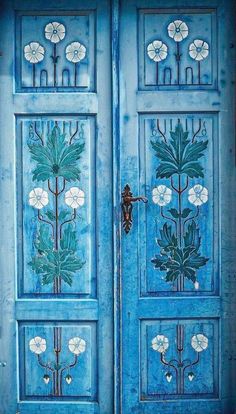 an ornate blue door with flowers painted on it