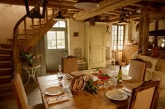 a wooden table topped with lots of food next to a staircase leading up to a kitchen