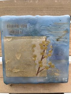 a piece of art that looks like it is made out of glass and has some yellow flowers on it