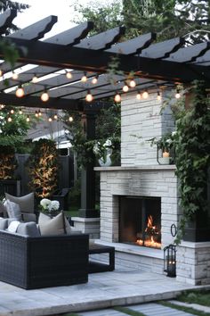 an outdoor living area with couches and fire place