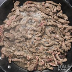 meat is cooking in a wok on the stove