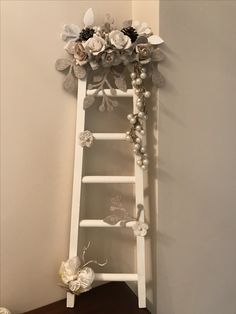 a white ladder decorated with flowers and pearls