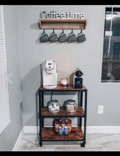 a coffee station with two shelves and cups on it, along with an espresso machine