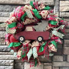 a christmas wreath with a red truck on the front and green polka dot ribbon around it