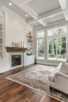 a large living room with white walls and wood flooring is pictured in this image