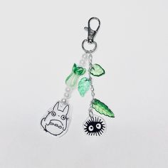 a keychain with an animal and plants hanging from it's side on a white background