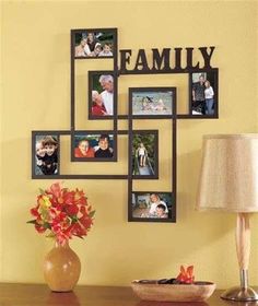 a family photo hanging on the wall above a table with a lamp and vase filled with flowers