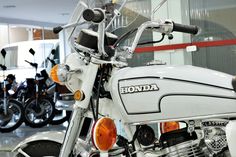 a white motorcycle parked inside of a building next to other motorbike's