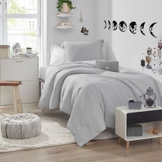 a bedroom with white walls and wooden floors, decorated in black and white decorations on the wall