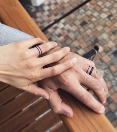 two people holding hands with rings on their fingers