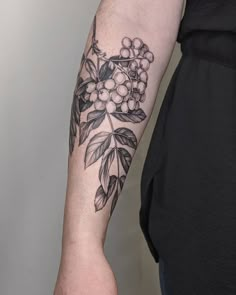 a woman with a tattoo on her arm holding onto a piece of fruit and leaves