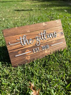 a wooden sign sitting in the grass