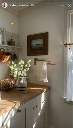 a kitchen counter with some flowers and eggs on top of it in front of a window