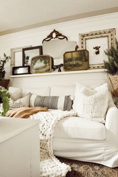 a living room filled with furniture and pictures on the wall