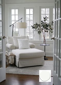 a living room with white furniture and windows