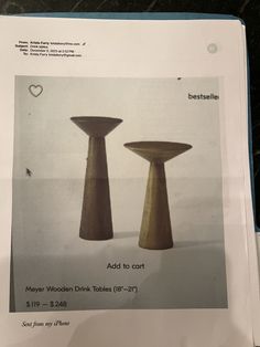 two wooden tables sitting next to each other on top of a table with white paper