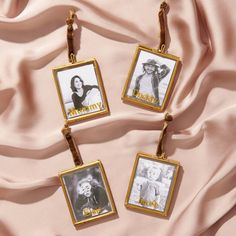 three pictures hanging from a gold frame on a pink fabric