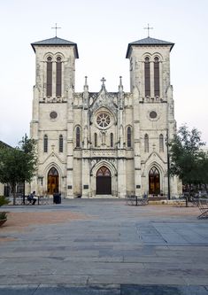 an old church with two tall towers on the front and side of it's entrance