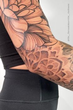 a woman's arm with tattoos on it and a flower in the middle of her arm