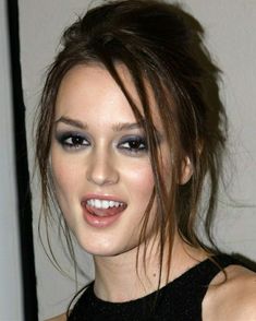 a close up of a person with makeup on and hair in a pony tail style