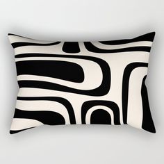 a black and white rectangular pillow with an abstract design on it's front side