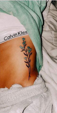 a woman's stomach with a small tattoo on her belly and the words, calvin klei above it