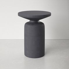 a grey stool with a black top on a white surface