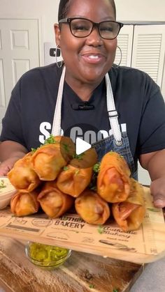 a woman sitting at a table with some food in front of her and smiling for the camera