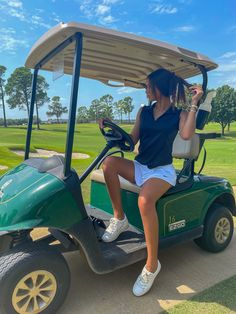 a woman is sitting on a golf cart