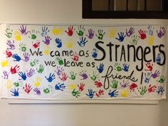 a sign that says we came as strangers, we leave as friends with hand prints on it