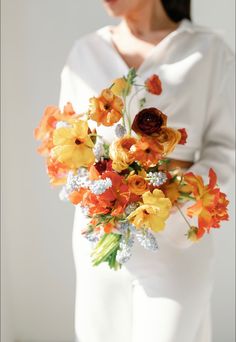 a woman holding a bouquet of flowers in her hands