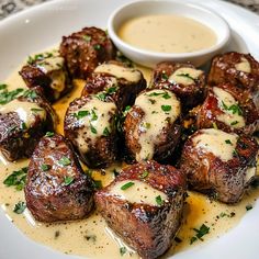 a white plate topped with steak covered in sauce and garnished with parsley