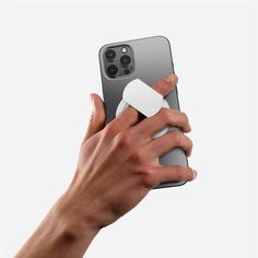 a person holding an iphone in their right hand and taking a selfie with the other hand