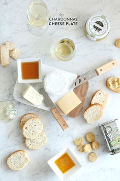 cheese and crackers are laid out on a marble counter top with wine, salt and pepper