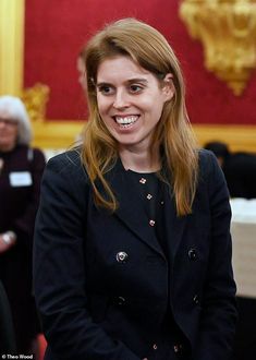 a woman in a black jacket smiles at the camera