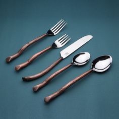 five spoons and two forks on a blue surface