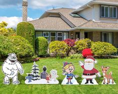 christmas yard decorations in front of a house with santa and other cartoon characters on the lawn