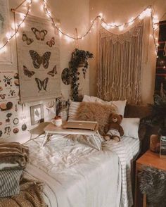 a bedroom with lights strung above the bed and stuffed animals on the wall next to it