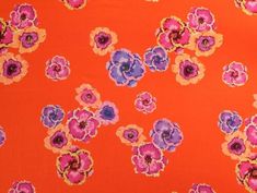 an orange background with pink and purple flowers