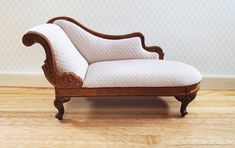 an old wooden chaise lounge chair with white upholster