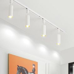 the lights are on above the bed in this bedroom with white walls and flooring