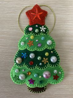 a felt christmas tree ornament hanging on a wall