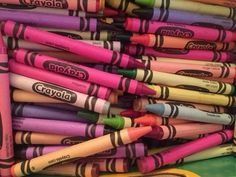 many different colored crayons are stacked on top of each other in a pile