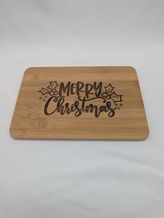 a wooden cutting board with merry christmas written on it