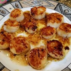 some scallops are sitting on a white plate