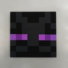 a black and purple square with squares on the bottom, in front of a white wall