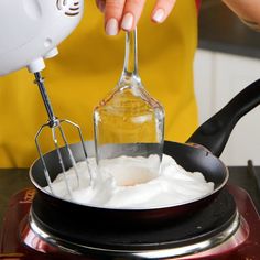 a woman is mixing whipped cream in a pot with a whisk and mixer