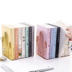 three books are stacked on top of each other in front of a pen and notebook