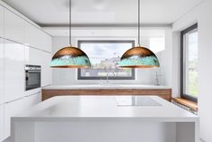 two pendant lights hanging over a kitchen island