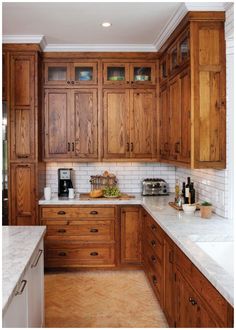 a kitchen with wooden cabinets and marble counter tops